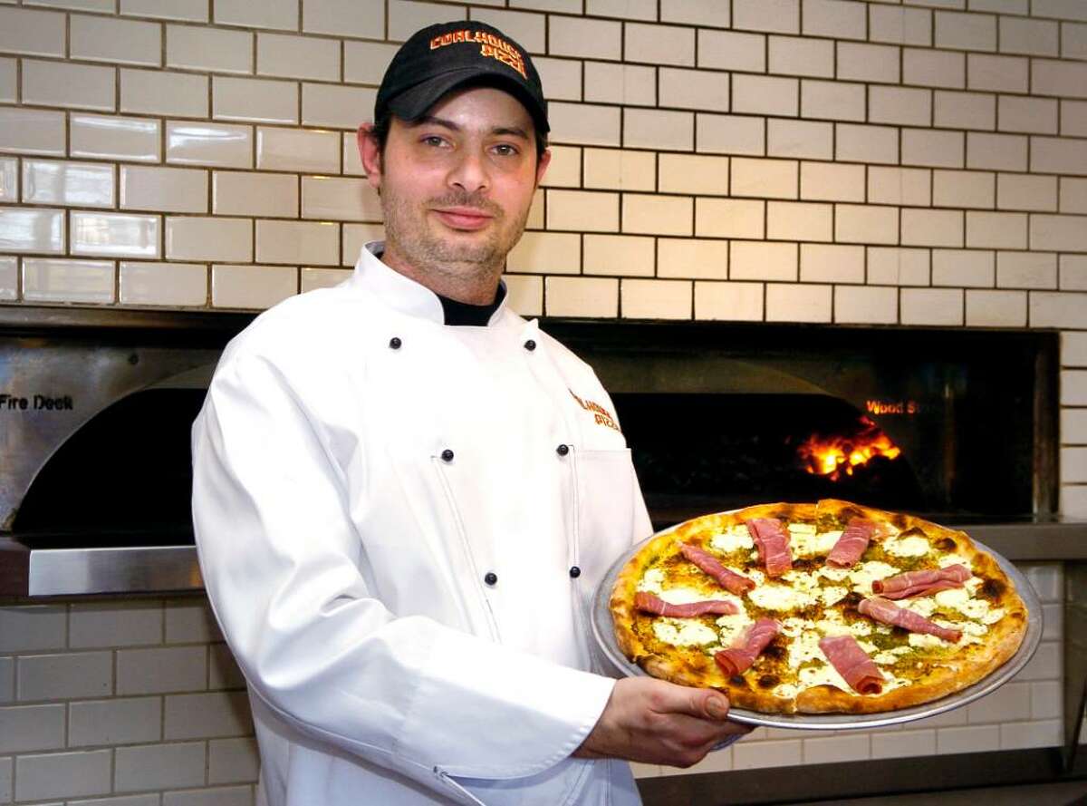 Chef Ciro Magliulo holds a " Favorite Things" pizza Coalhouse Pizza in the Bull's Head Shopping Center in Stamford, Conn. on Thursday April 1, 2010.The pizza has oven-roasted garlic, mozzarella and ricotta cheese,fresh rosemary, homemade pesto and prosciutto on it.