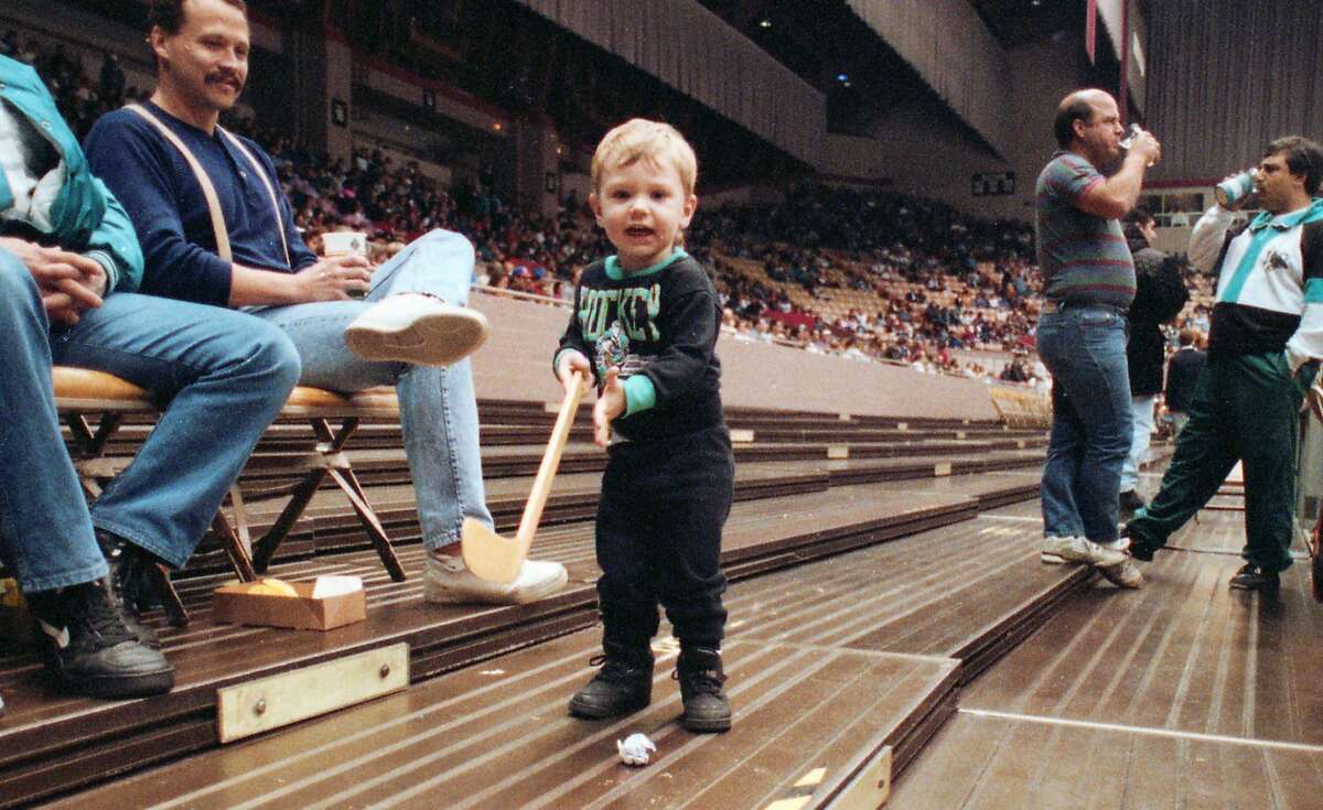 A young Sharks fan plays with a makeshift puck on April 4, 1993, during the team's early years when they played at the Cow Palace in Daly City.