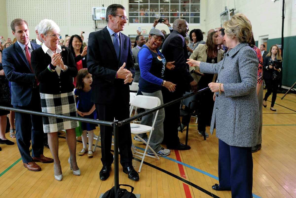 Democratic presidential candidate Hillary Clinton, right, accompanied by Connecticut Gov. Dannel P. Malloy, speaks with an attendees during a campaign event, Thursday, April 21, 2016, in Hartford, Conn. Clinton stopped in Hartford for a discussion on gun violence prevention with family members of gun violence victims. (AP Photo/Jessica Hill)