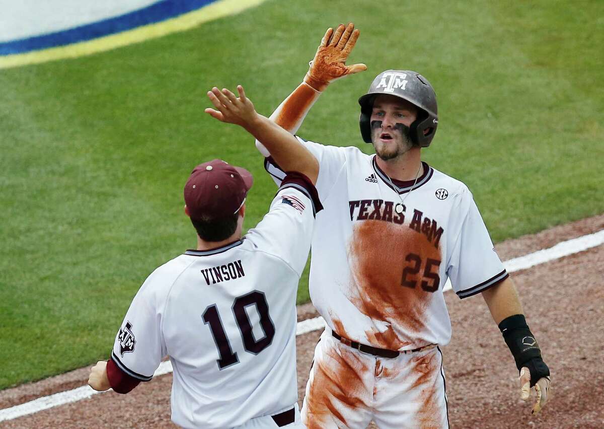 Texas A&M's Austin Homan, right, high-fives teammate Andrew Vinson after scoring one of the Aggies' seven first-inning runs against Vanderbilt in the Southeastern Conference tournament Friday at Hoover, Ala.