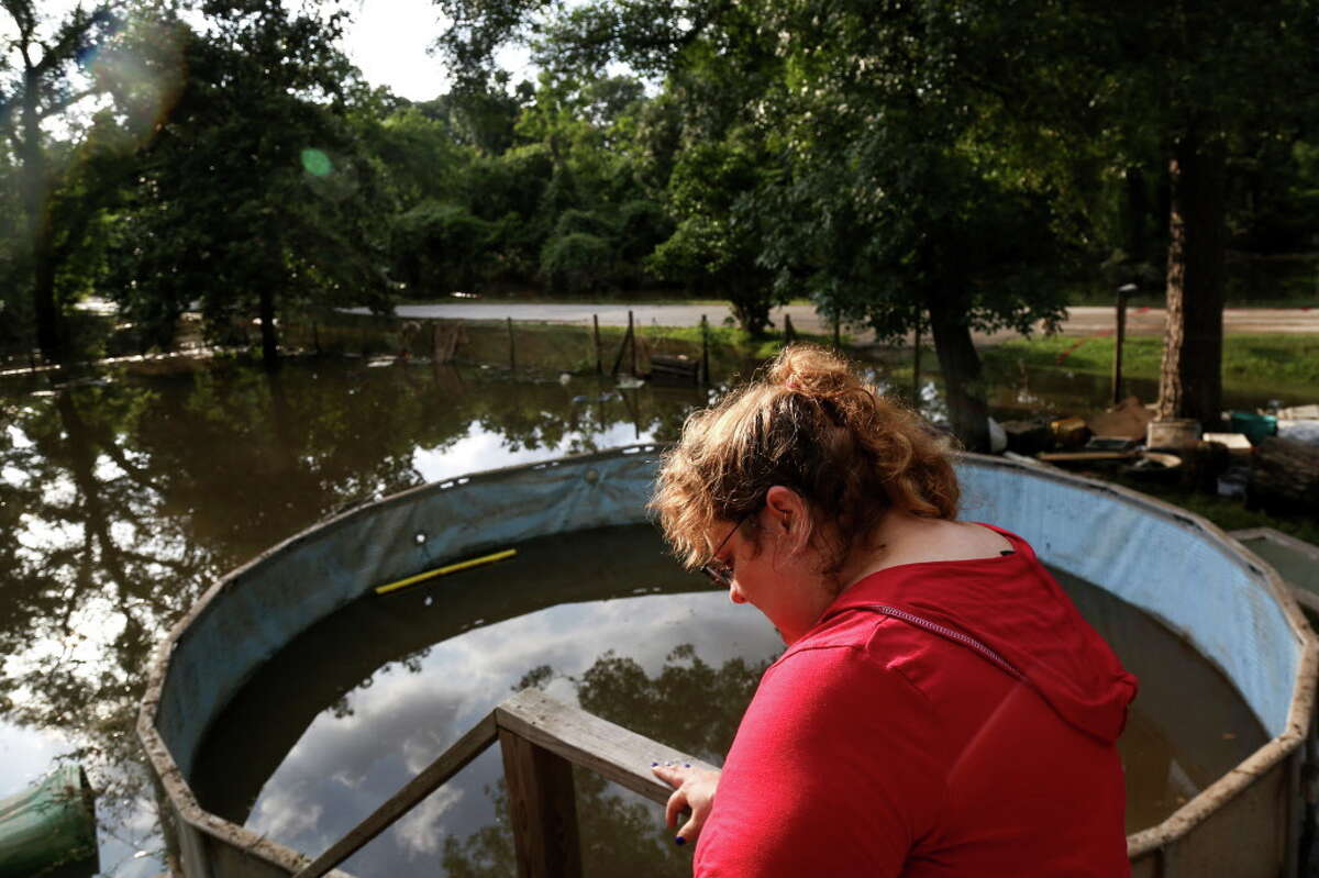Hazel Smith looks out at her flooded property Saturday, May 28, 2016, in Tomball. The home, which sits at least two feet off the ground, had at least two feet of water in it the night before. "I've been staying with neighbors I'd never met before the flood," she said. "I honestly don't care about the material things, but it's all that hard work." Smith said she works two jobs.