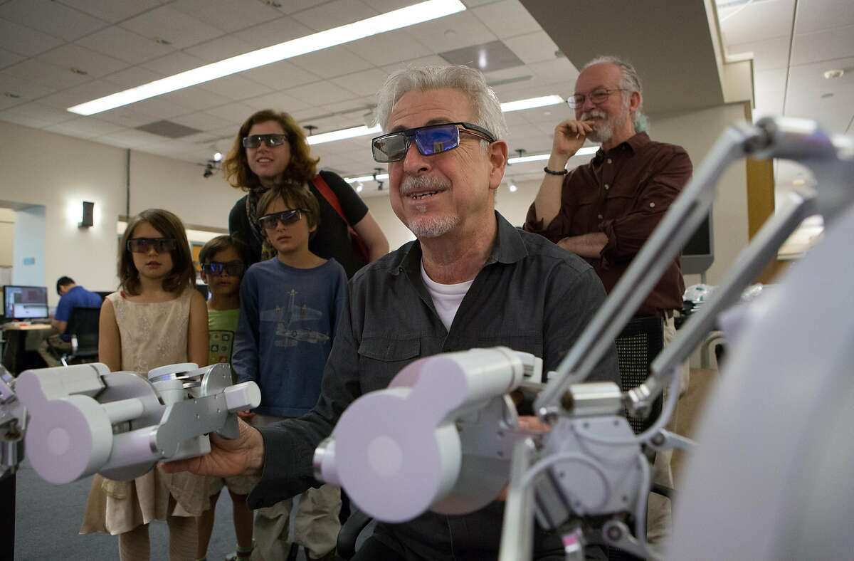 (left to right) Harriet Won, 7, Anders Nystol,7, Julius Won, 9, Andrea Won and Professor Kenneth Salisbury early watch as Stanford professor Oussama Khatib (front center) demonstrates how to use the haptic devices that control Ocean One while at Stanford University on Friday, May 27, 2016.