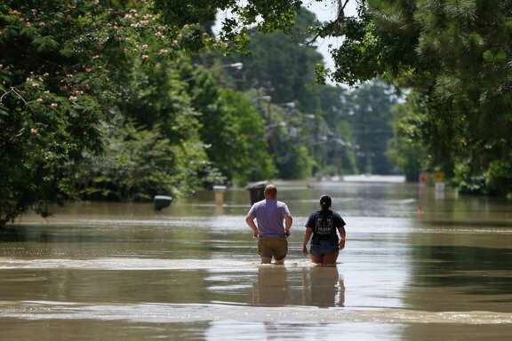 Residents walk through flood waters on Hamblen Road in the Forest Cove neighborhood, south of Kingwood, where flood waters from the San Jacinto Rivers reached levels not seen since 1994, Sunday, May 29, 2016, in Humble.