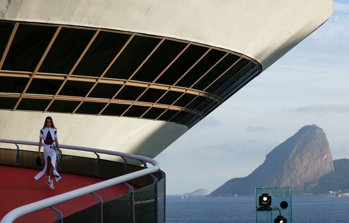 A model walks down a ramp of the Contemporary Art Museum wearing a creation from the Louis Vuitton Crusie 2017 collection, in Niteroi, Brazil, Saturday, May 28, 2016. The elite of the fashion world flocked to Brazil, defying an outbreak of the Zika virus, an economic meltdown and the profound political crisis afflicting the country to attend a runway show Saturday by revered French label. The iconic Sugarloaf Mountain is pictured in the background on right. (AP Photo/Leo Correa) ORG XMIT: XLC113