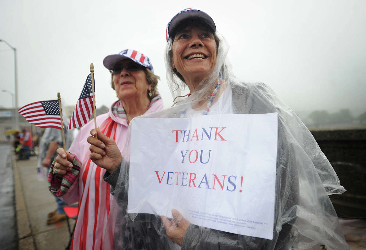 Ginny Colabella, left, of Norwalk, and her daughter Tracy Fascio, of Shelton, keep dry as they show their support for veterans during the Shelton/Derby Memorial Day parade on Monday, May 30, 2016.