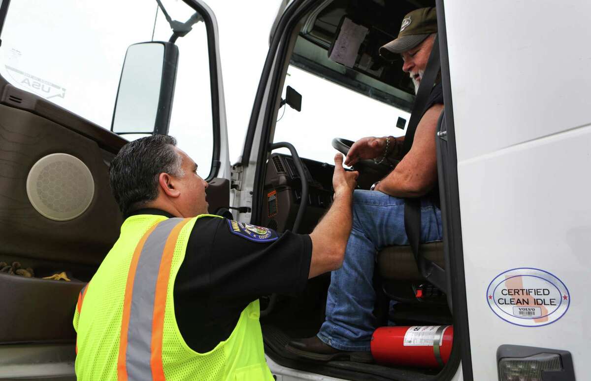 Javier Flores, left, a member of the County of Bexar Environmental Law Enforcement team, talks with truck driver Buster Hutchins of Dallas, to let drivers know about the anti-idling restrictions, on Tuesday, May 17, 2016, at the Flying J Travel Plaza on I-10 east.
