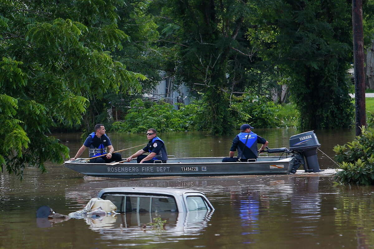 Rosenberg fire fighters motor past submerged cars and homes as they survey the damage along the Brazos River Tuesday, May 31, 2016 in Rosenberg.