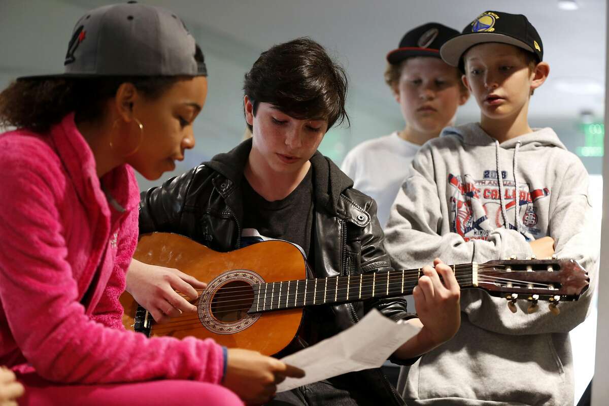 7th graders Serafina (left) and Riley perform a song they wrote during House Minority Leader Nancy Pelosi's, D-San Francisco, trip to Children's Day School in San Francisco, California, on Tuesday, May 31, 2016.