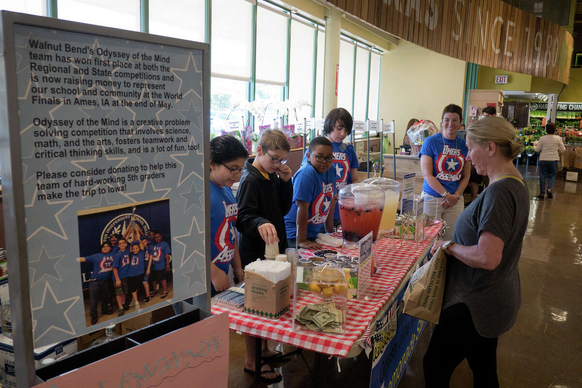 Members of Walnut Bend Elementary's Odyssey of the Mind team Sean Laguna, left, Tomas de Rijk, Rheese Richardson and Dylan Kahler talk with customer Toni Hudgins while assistant coach Karen Wallace keeps an eye on things while the pupils sell lemonade to finance their trip to the world competition in Ames, Iowa.