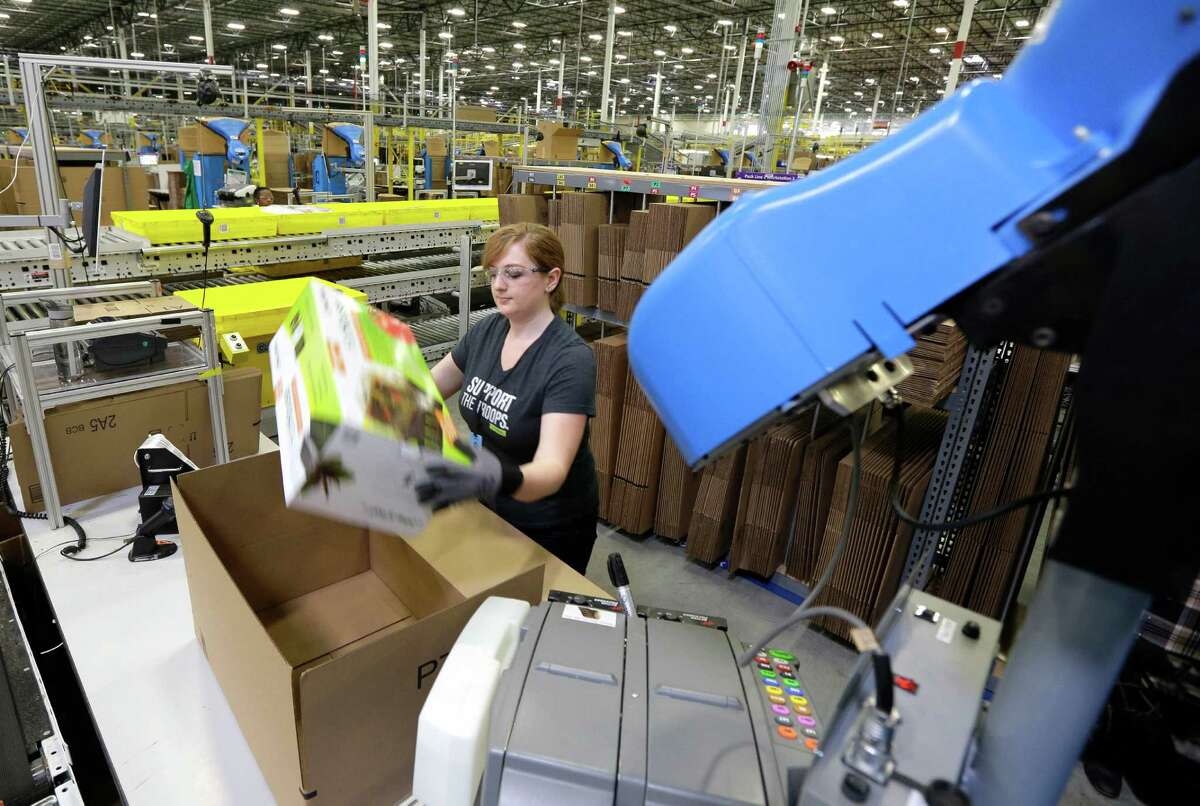 In this Feb. 13, 2015 file photo, a worker places an item in a box for shipment during a media tour of the new Amazon.com fulfillment center in DuPont, Wash. San Marcos officials lured the company to build a center there by passing an incentive package that would refund the company 85 percent of personal property taxes and 40 percent of real property taxes for the next decade. Amazon will also receive partial refunds of its sales taxes for two decades.