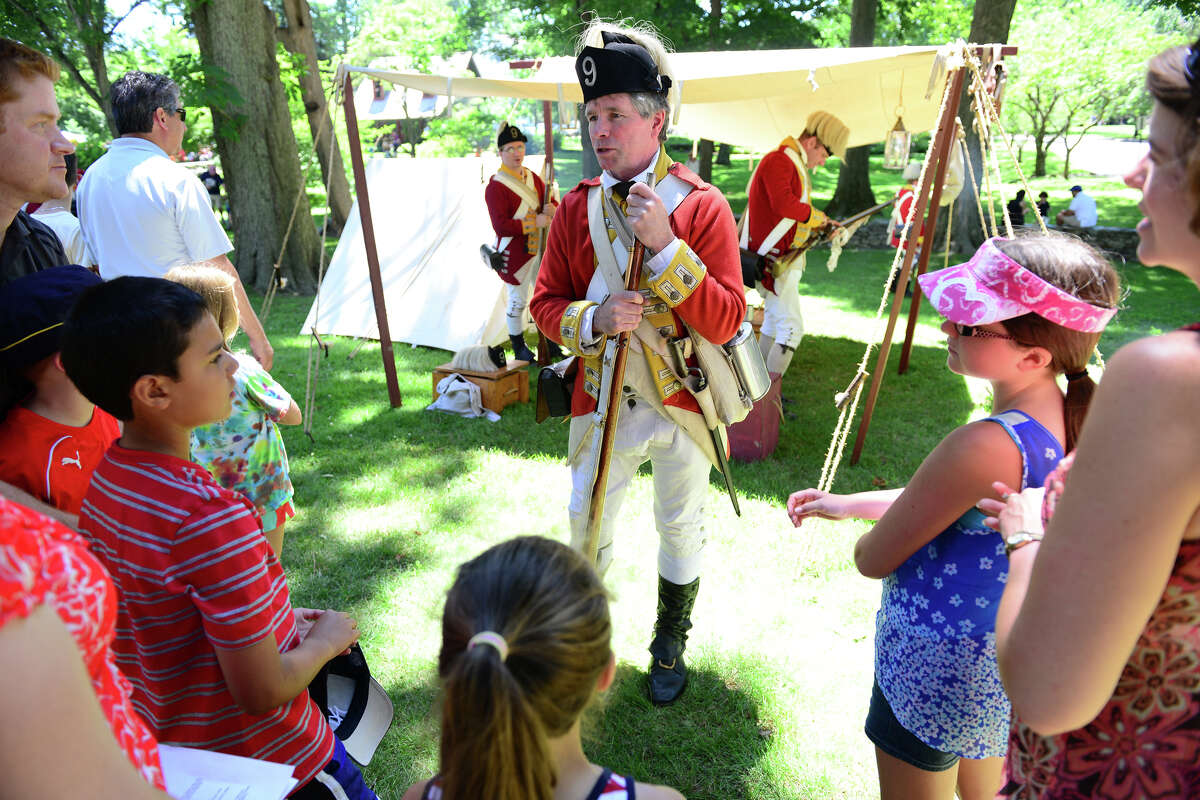 Revolutionary War re-enactor Jim Murphy, with the British Seventh Company of the Ninth Regiment of Foot, answers questions during Family Fun Fest held on the Town Hall Green and the Fairfield Museum and History Center in Fairfield, Conn. on Saturday July 5, 2014. Those who have Bank of America and Merrill Lynch credit and or debit cards, can get free admission to the Fairfield Museum and History Center the first full weekend of each month in 2016.