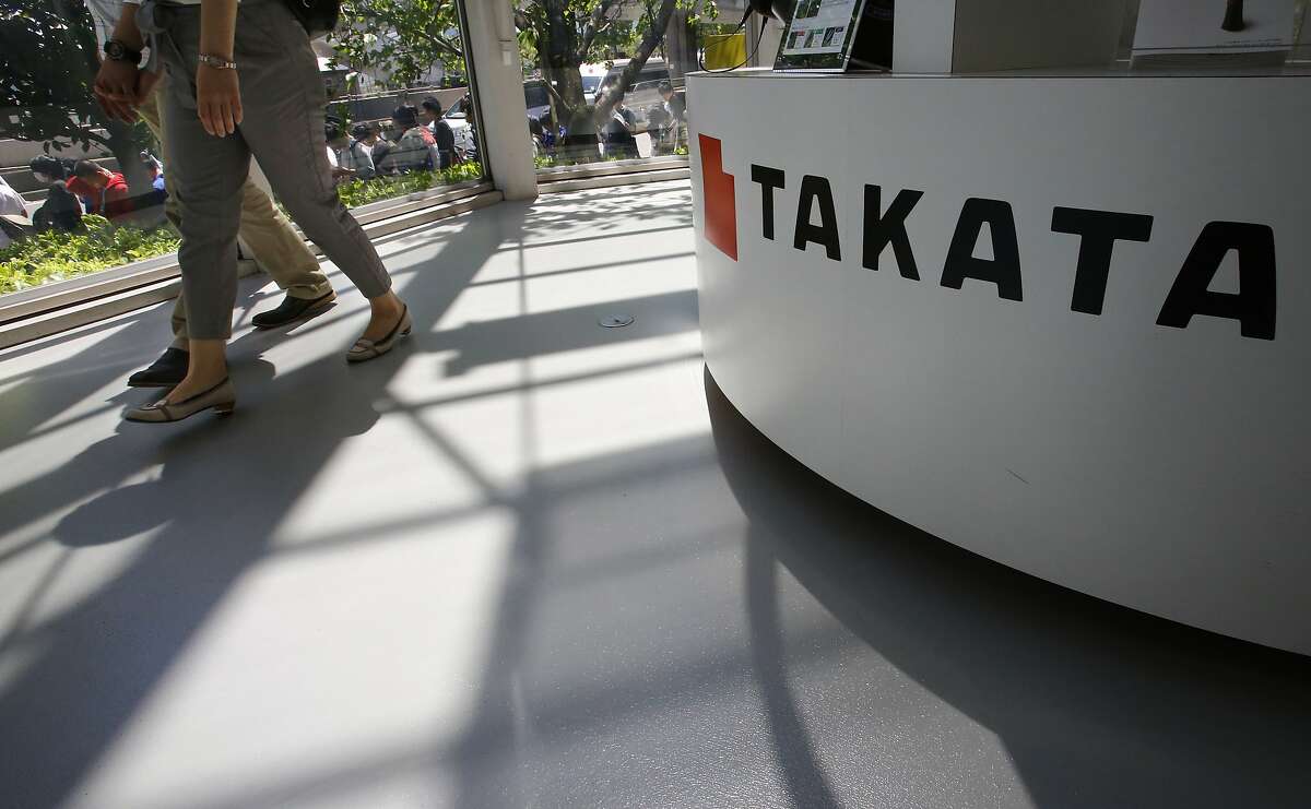 FILE - In this May 4, 2016, file photo, visitors walk by a Takata Corp. desk at an automaker's showroom in Tokyo. A U.S. Senate report says at least four automakers are selling new vehicles that have potentially deadly Takata air bag inflators. The report by Commerce Committee Democrats says some 2016 and 2017 models from Fiat Chrysler, Mitsubishi, Toyota and Volkswagen have a type of inflator that is prone to rupture and presents a potential danger to drivers and passengers. (AP Photo/Shizuo Kambayashi, File)