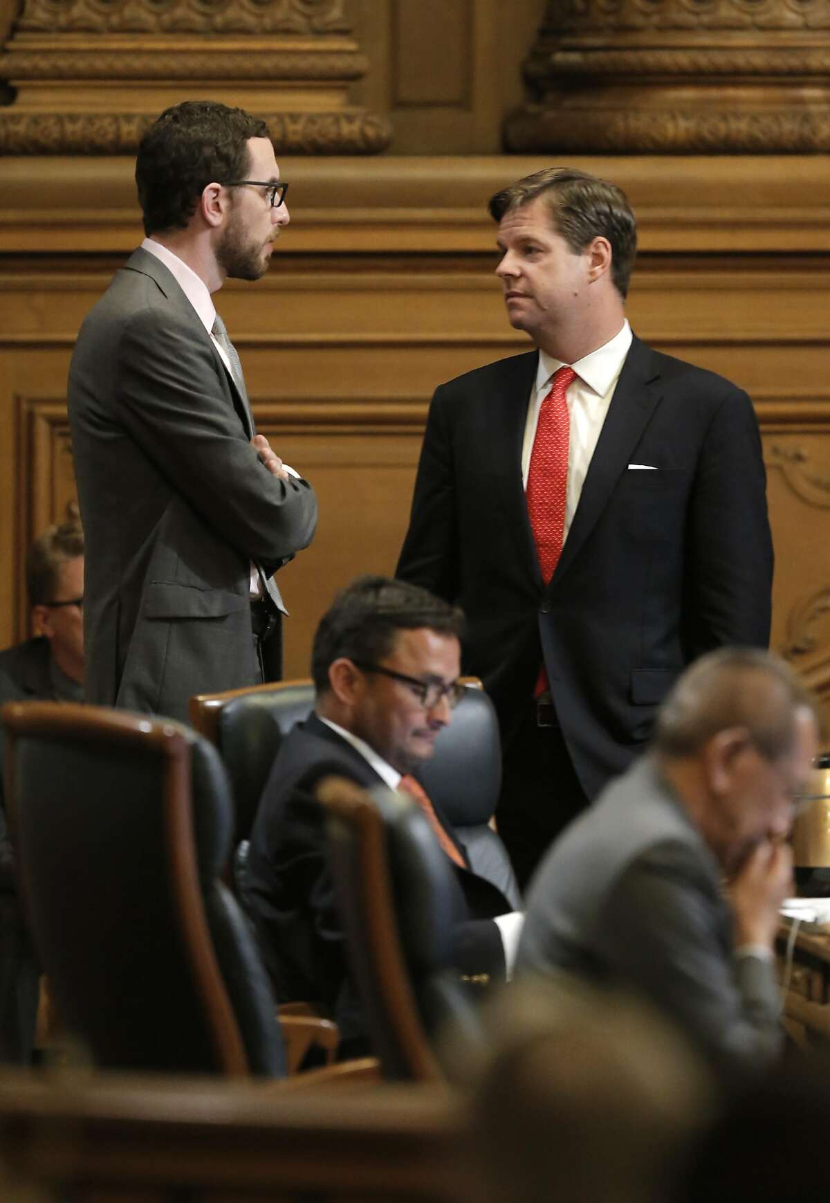 Supervisor's Scott Wiener, (left) and Mark Farrell discuss the proposals as the San Francisco Board of Supervisor prepared to vote on competing measures to regulate Airbnb and other short-term rental services in San Francisco, Calif., on Tues. July 14, 2015.