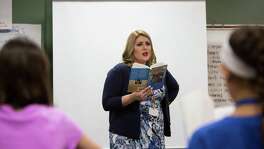 Sara Scarborough, a sixth-grade teacher at Bleyl Middle School, reads "The Giver" to students last month.