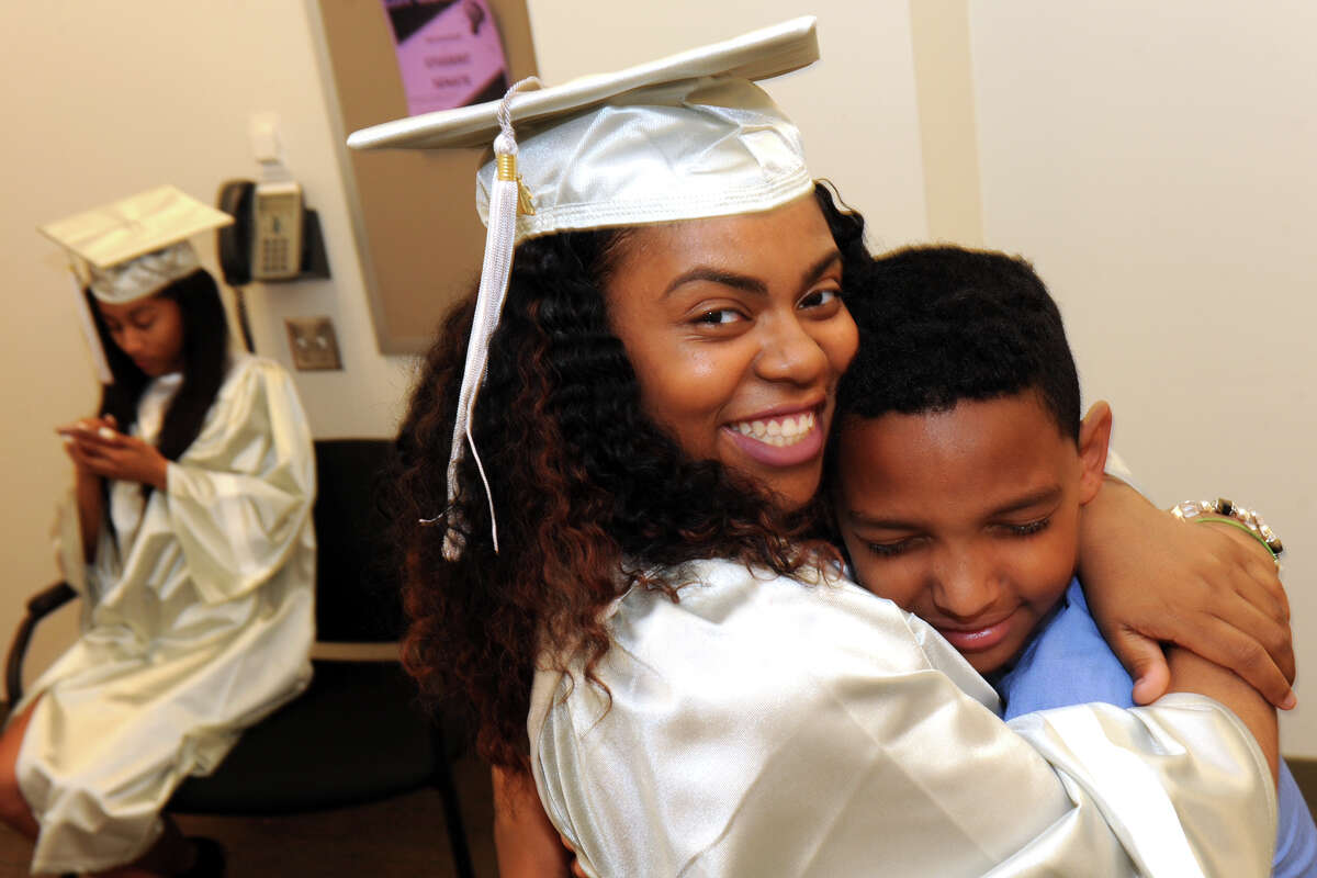 Graduate Tiajah Smith gets a hug from Walker Perry, son of Capital Preparatory Harbor School head Dr. Stephen Perry at the school's First Annual Commencement, held at Housatonic Community College in Bridgeport, Conn. June 1, 2016.