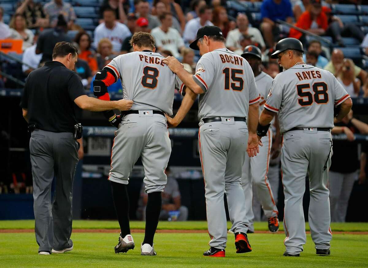 Hunter Pence of the San Francisco Giants is helped off the field by manager Bruce Bochy after injuring his leg pulling up short running to first base on a ground out in the fourth inning against the Atlanta Braves.