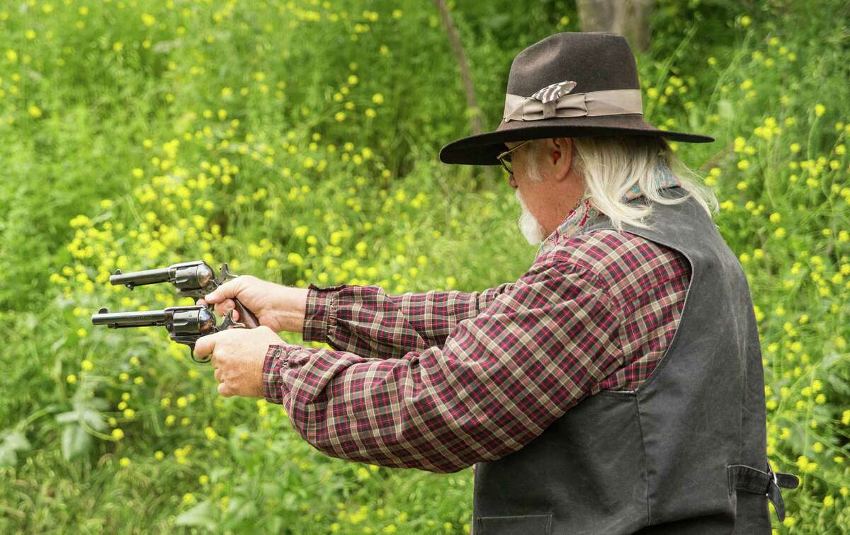 Mike Franklin, president of the South Texas Pistoleros, fires his guns during a cowboy action shooting match at A Place to Shoot, a shooting range near San Antonio, on April 4, 2015.