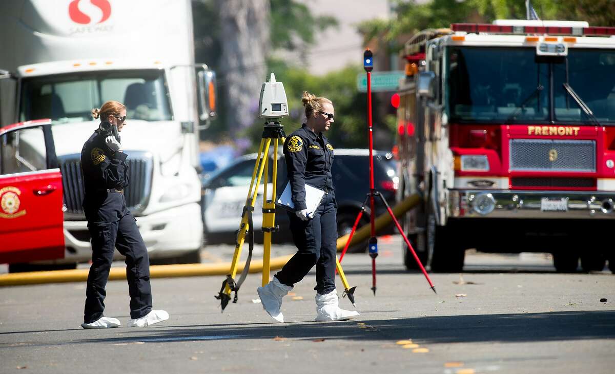 An Alameda County crime lab technician approaches a burned out home on Roberts Ave. in Fremont, Calif., on Thursday, June 2, 2016. Gerald Villabrille Jr., suspected of shooting two officers on Wednesday, was found dead inside the residence according to Fremont police.