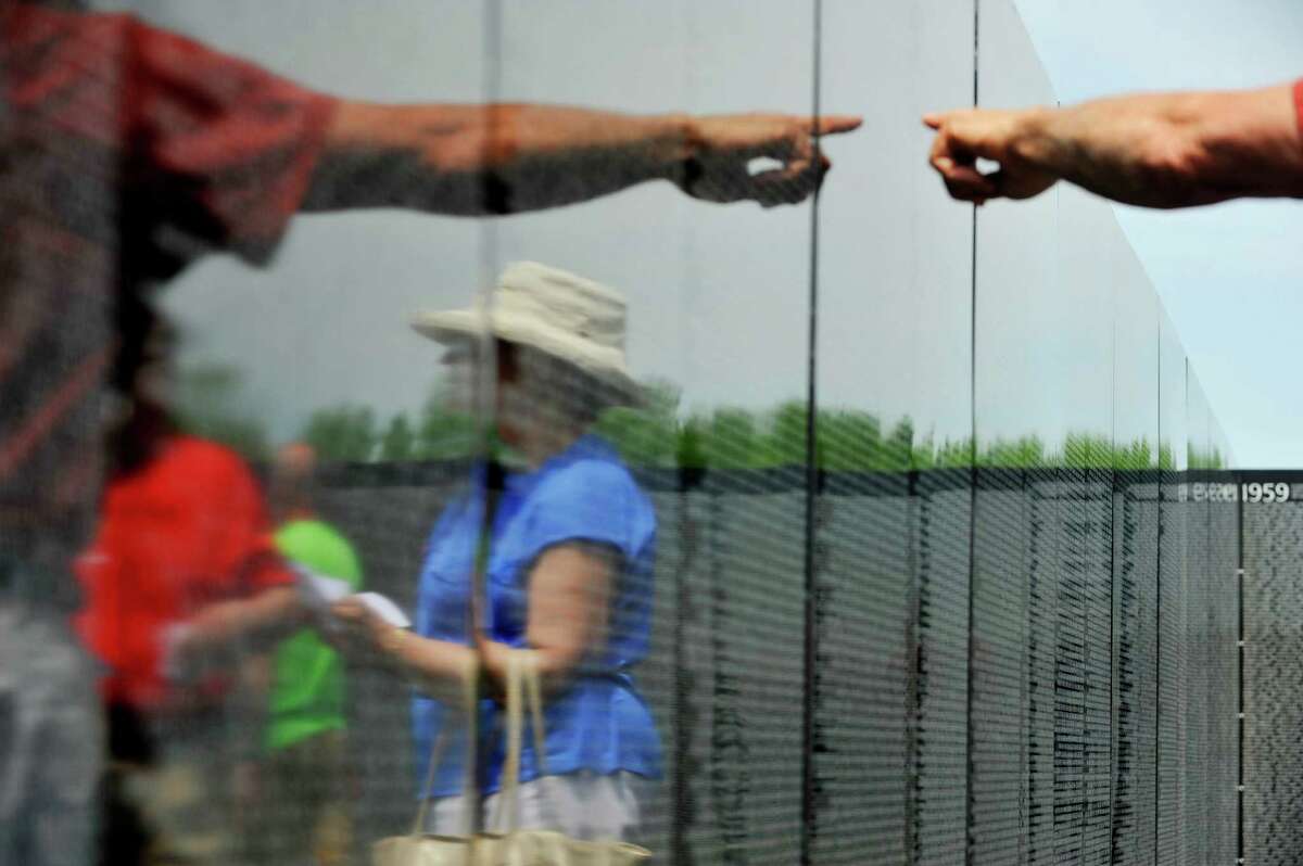 Visitors are reflected in the half-size replica of the Vietnam Veterans Memorial at Halfmoon Town Park on Thursday, June 2, 2016. The memorial will be on display at the town park through June 6th. (Paul Buckowski / Times Union)