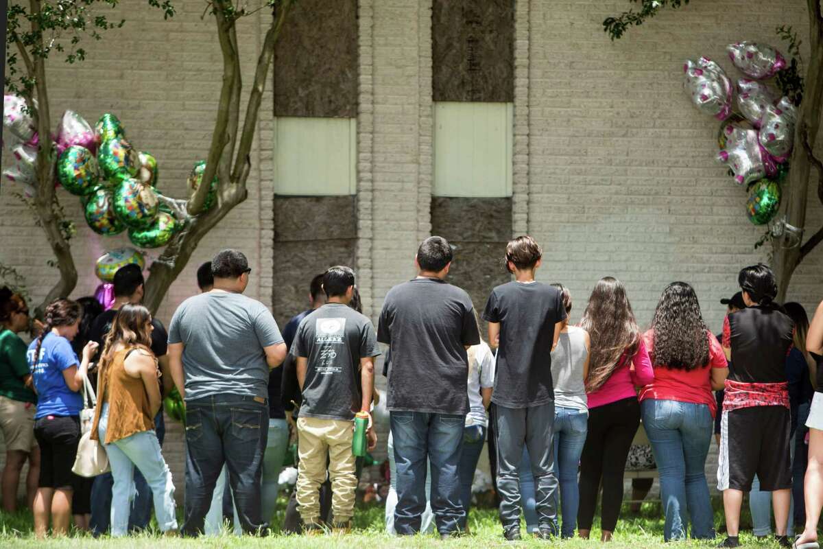 Mourners stand near a makeshift memorial for 15-year-old Karen Perez on Tuesday, May 31, 2016, in South Houston. It was early Tuesday morning when Tim Miller with Texas Equusearch confirmed Perez was found dead overnight in an abandoned apartment complex at Avenue N and 16th Street, next to South Houston High School. A juvenile suspect is in custody and murder charges are pending, the City of South Houston Police tell KHOU 11 News. ( Brett Coomer / Houston Chronicle )