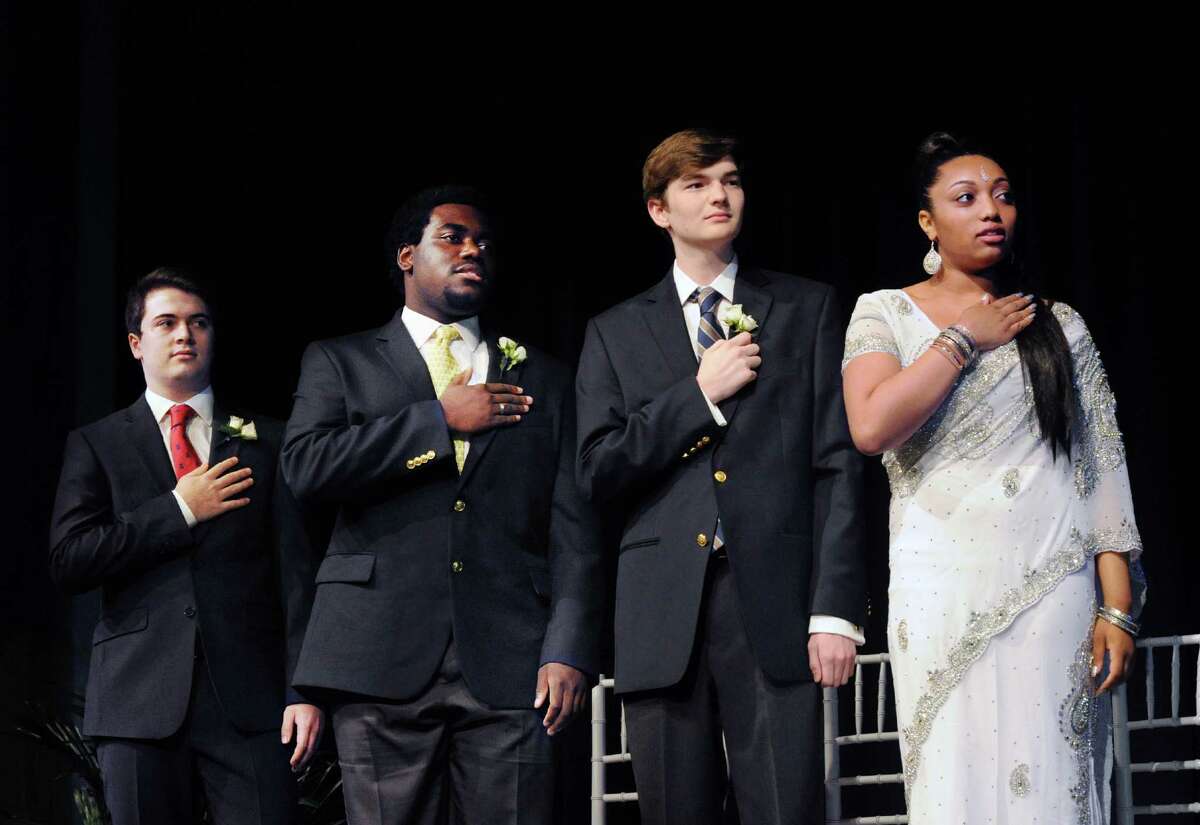 Stanwich School graduating seniors, from left, Eric Castro, 18, Ian Davis, 18, Christopher Gardner, 18, and Niaomi King, also 18, during the Pledge of Allegiance at the start of the commencement at the school in Greenwich, Conn., Thursday, June 2, 2016.