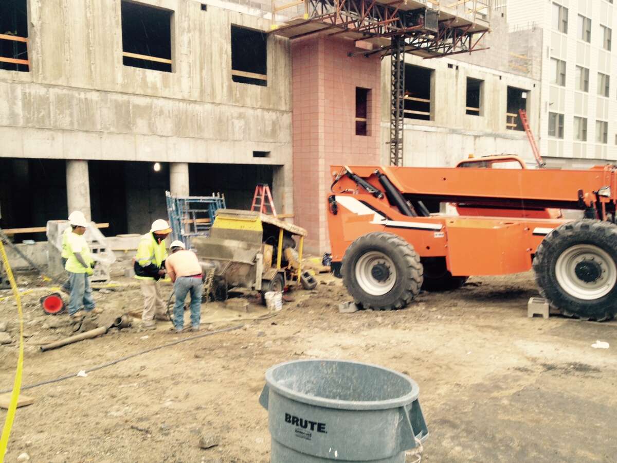 A 31-year-old construction worker was injured Friday morning when a fork lift (orange) rolled backwards and struck a liquid concrete pump (yellow), throwing the worker to the ground at the Metro Green III apartments in Stamford on June 3, 2016.