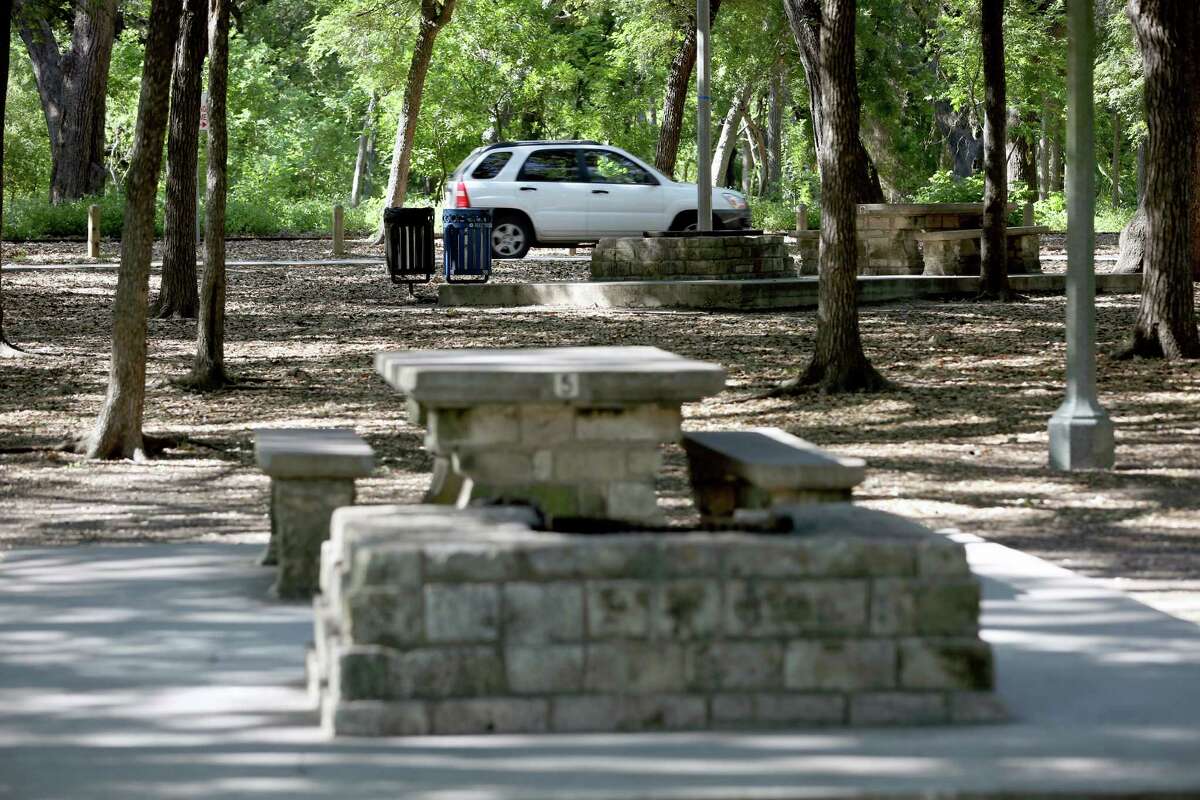 A car drives last month along Brackenridge Drive in the heart of Brackenridge Park. Removing some of the streets and parking spaces and having people leave their cars at a private parking garage on the park's fringes are some of the ideas included in a draft master plan for the park.