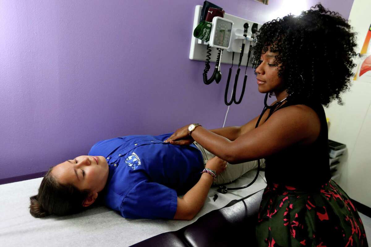 Nurse Practitioner Ashley Cockrell examines Layla Aguilar, who is complaining of a stomach ache, in the KIPP Care clinic at KIPP Explore Academy, Thursday, May 12, 2016, in Houston, Texas. KIPP Care is a partner with Legacy Community Health Services. ( Gary Coronado / Houston Chronicle )