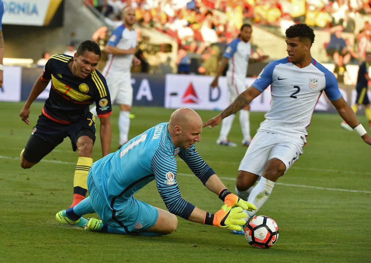 USA's Brad Guzan dives to grab the ball next to Colombia's Carlos Bacca and USA's DeAndre Yedlin during the Copa America Centenario football tournament in Santa Clara, California, United States, on June 3, 2016. / AFP PHOTO / MARK RALSTONMARK RALSTON/AFP/Getty Images