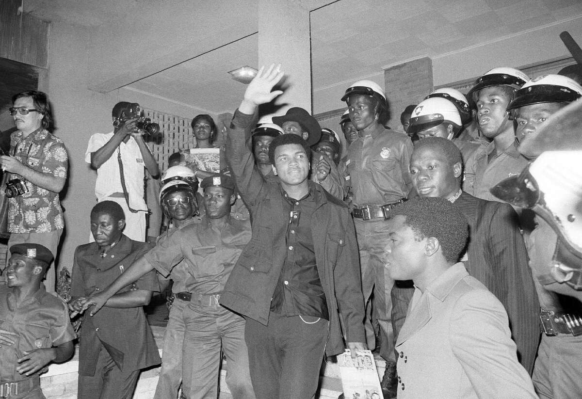 FILE - In this Sept. 11, 1974, file photo, heavyweight title challenger Muhammad Ali, surrounded by Zaire soldiers, waves to crowd upon his arrival in Kinshasha, Zaire. Ali is in Zaire for a fight against George Foreman. Ali, the magnificent heavyweight champion whose fast fists and irrepressible personality transcended sports and captivated the world, has died according to a statement released by his family Friday, June 3, 2016. He was 74.