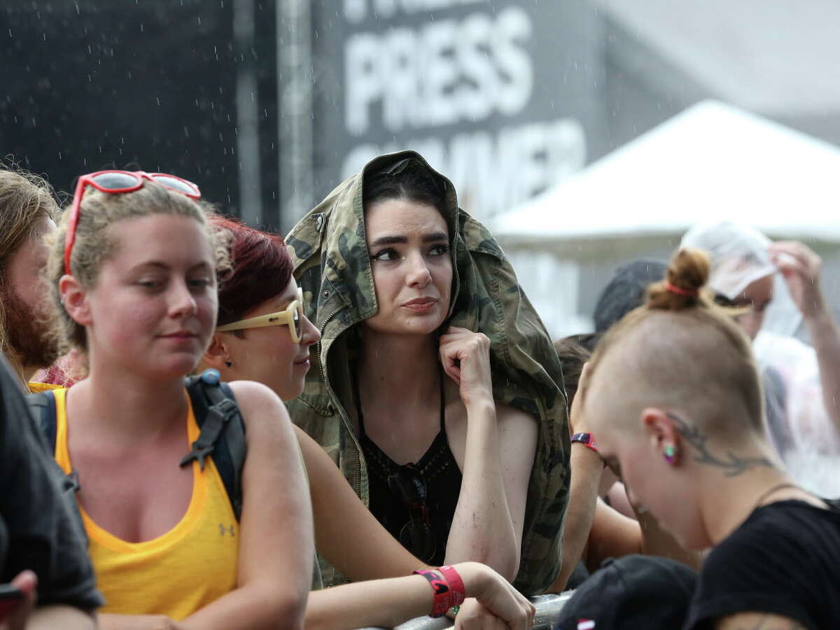 Caroline Hubble waits in the rain for Gogol Bordello to perform at Free Press Summer Fest, at NRG, Saturday, June 4, 2016, in Houston.