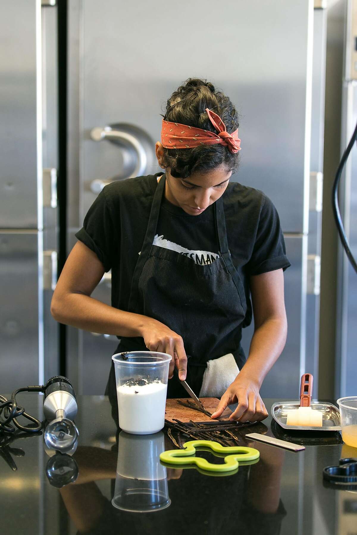 Yamina Marzoug scrapes out vanilla beans at the Den in S.F.