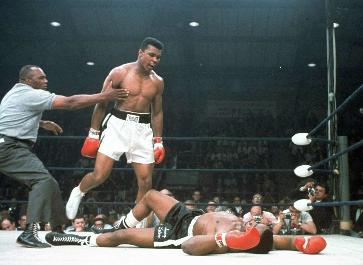 In this May 25, 1965, file photo, heavyweight champion Muhammad Ali is held back by referee Joe Walcott, left, after Ali knocked out challenger Sonny Liston in the first round of their title fight in Lewiston, Maine. Ali transcended the sport. If you were a black kid growing up in the 1960’s and 1970’s Ali’s words, his style, his audacity was liberating and uplifting.