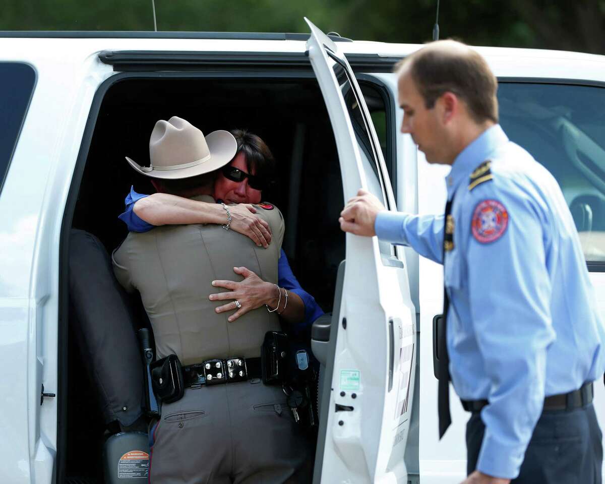 Denise Corliss, handler for Bretagne, the last surviving search and rescue dog from 9/11, gets a hug from a trooper with the Texas Highway Patrol, after Bretagne's body was loaded into a Texas Task Force 1 vehicle, and taken to Texas A&M, after she was brought into the Fairfield Animal Hospital, Monday, June 6, 2016, in Cypress, to be euthanized.
