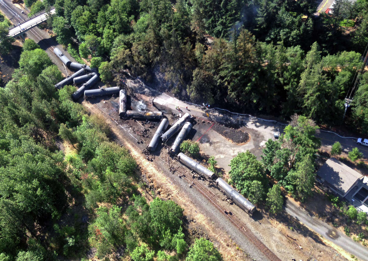 This aerial view provided by the Washington State Department of Ecology shows scattered and burned oil tank cars, Saturday, June 4, 2016, after the train derailed and burned near Mosier, Ore., Friday. Union Pacific Railroad says it had recently inspected the section of track near Mosier, about 70 miles east of Portland, and had been inspected at least six times since March 21. (Washington Department of Ecology via AP)