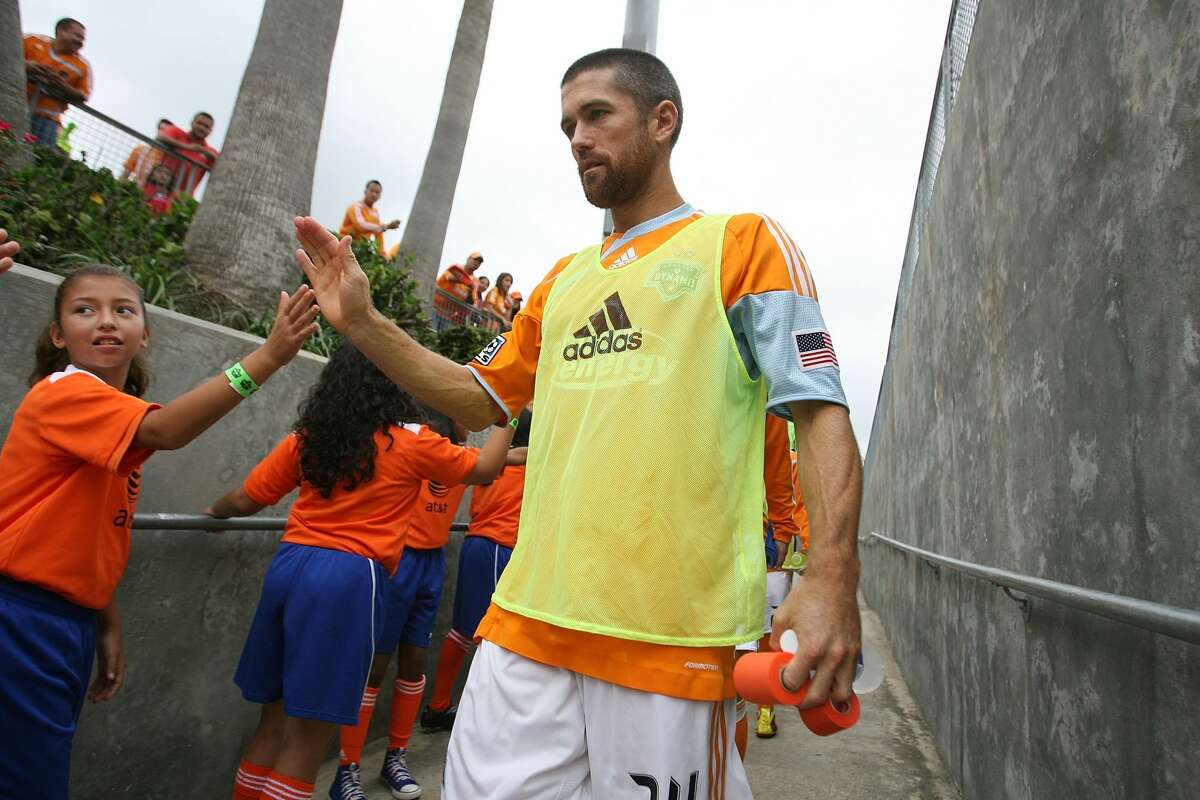 HOUSTON - NOVEMBER 08: Wade Barrett #24 of the Houston Dynamo high fives fans while he walks down the ramp to the pitch before the Houston Dynamo play against the Seattle Sounders on November 8, 2009 at Robertson Stadium in Houston, Texas. (Photo by Thomas B. Shea/MLS via Getty Images)