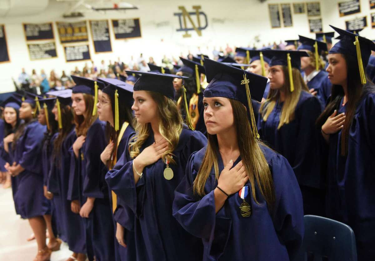 Rachael Watcke, of Shelton, puts her hand over her heart for the National Anthem before the Notre Dame High School commencement ceremony at Notre Dame High School in Fairfield, Conn. Friday, June 3, 2016.