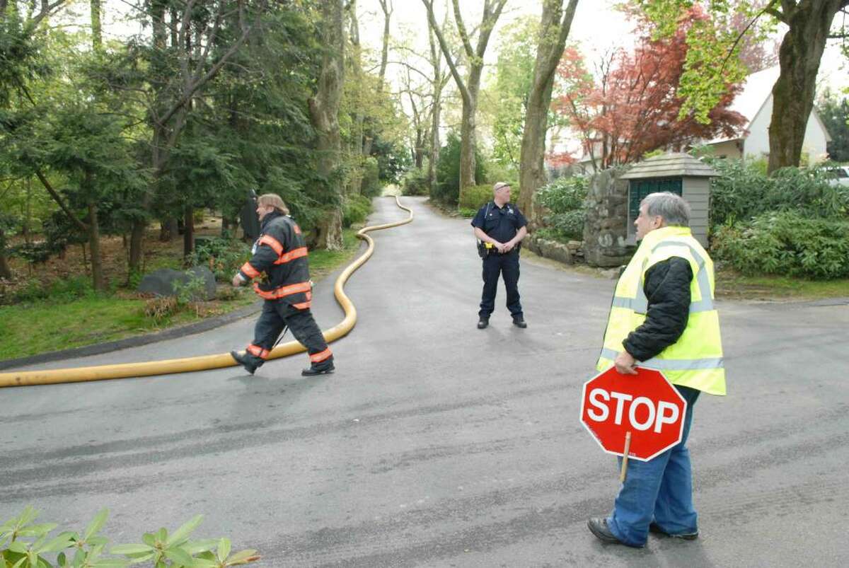 Greenwich fire and police officials near the scene of an attic fire in the private section of Mead Point on Indian Field Road Wednesday morning. Photo by John Ferris Robben.