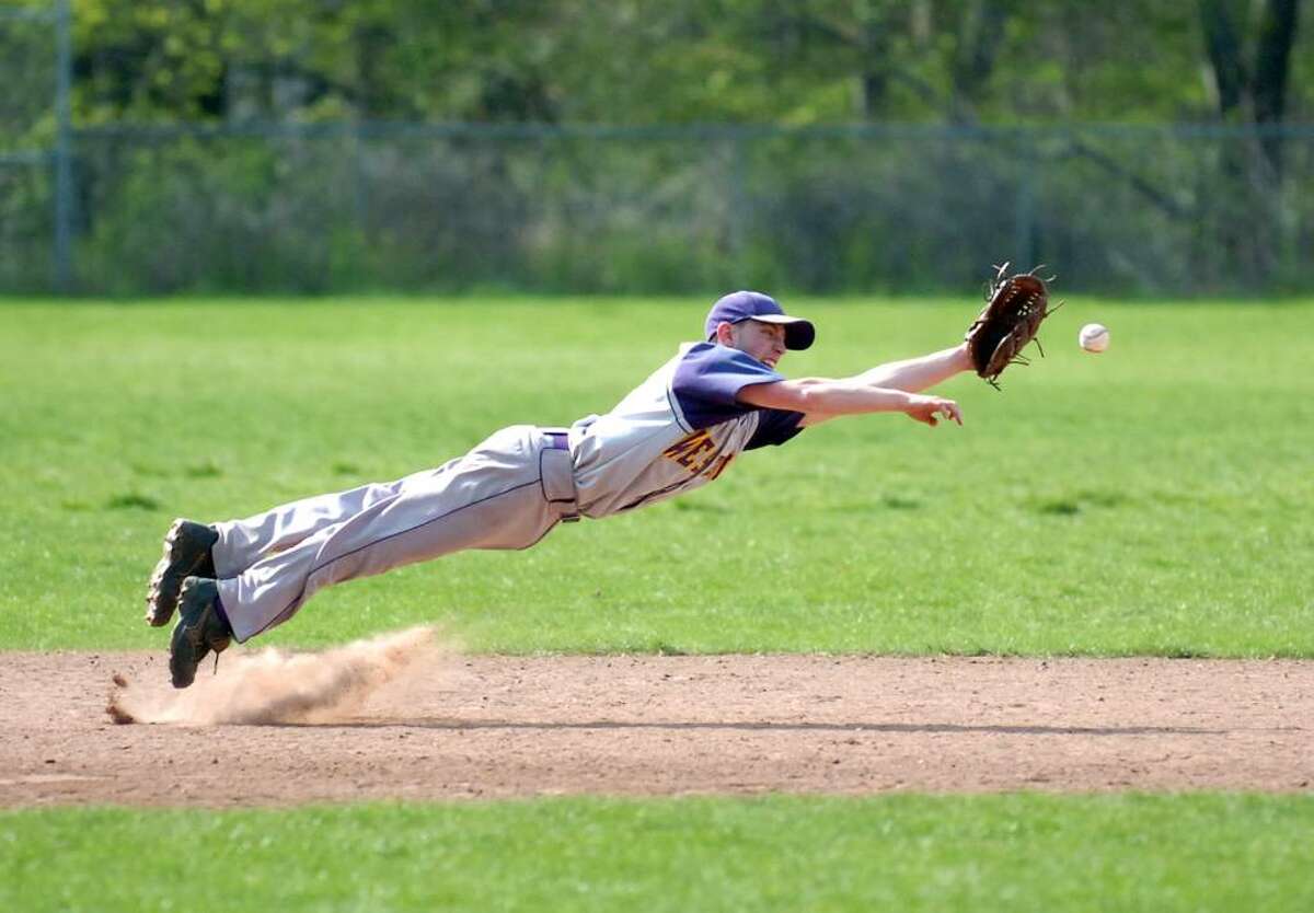 Westhill's Scott Valenzano dives for a ball as Trinity Catholic hosts Westhill High School in a boys baseball game Wednesday, April 21, 2010. Westhill won 5-1.