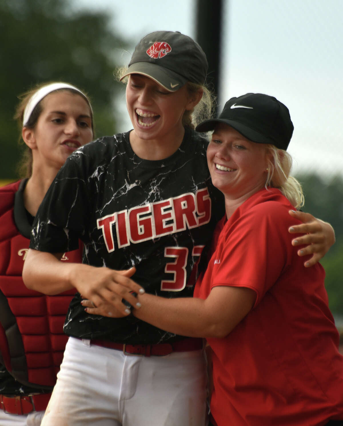 Katy junior pitcher Kylie Redding, center, gets a hug from acting head coach Meghan Brown after finishing game 3 of the Tiger's Region III-6A semifinal playoff series matchup against Alvin at Katy High School on May 21, 2016. (Photo by Jerry Baker/Freelance)