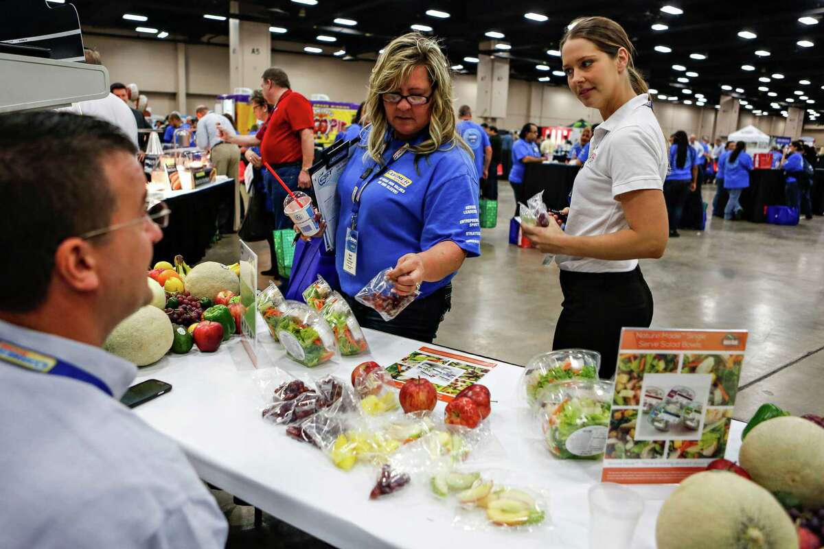 CST store manager from Paso Robles, Ca., Terri larson, center, sampling fresh salads, vegetables, and fruit available at the CST Brands Inc. trade show hosted for over 1000 CST store managers in Exhibit Hall A at the Henry B. Gonzales Convention Center downtown on Jan 20, 2015. Activist investors upset over CST Brands Inc.’s stock price have convinced the company to consider a sale.
