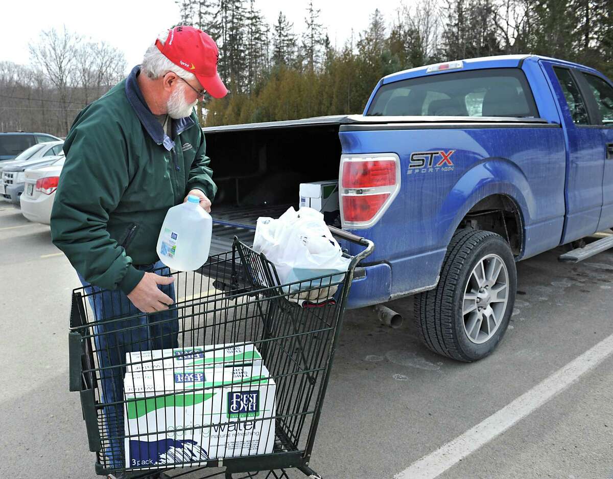 Mike McGuire of Hoosick Falls loads spring water, bought at Tops grocery store, into the back of his pickup truck on Friday, Feb. 12, 2016 in Hoosick Falls, N.Y. McGuire has been a resident of Hoosick Falls for 63 years and worked at Saint-Gobain for 41 years. (Lori Van Buren / Times Union)