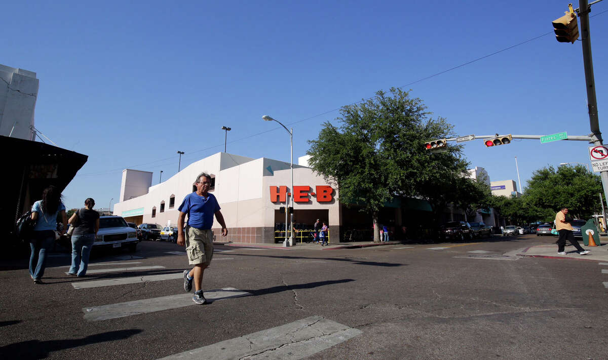 Pedestrians cross the street in front of Laredo’s downtown H-E-B. H-E-B announced May 27 that the company will be closing this store June 26.