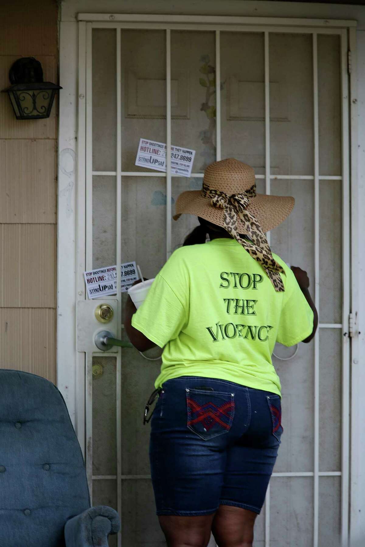 A member of the San Antonio Metropolitan Health District's violence prevention program, Stand Up S.A., places informational cards at the house where five-year-old Ana Garza lived on the 800 block of Pecan Valley, Wednesday, June 8, 2016. Garza and her relative, Carlos Aguilar, were shot on June 1 at the house. She died today. The young girl was asleep in the house when the shooting occurred and a bullet hit her on the head.