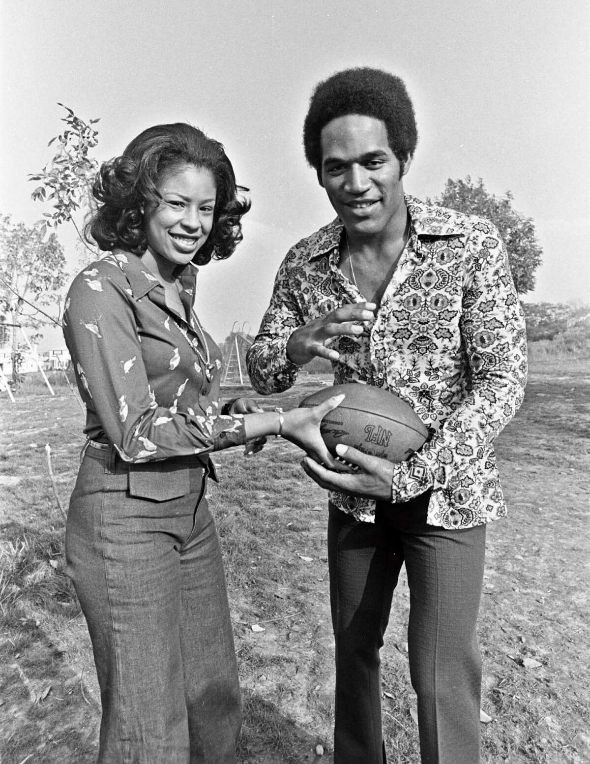 In this 1973 image released by ESPN Film, football player O.J. Simpson appears with his wife Marguerite L. Simpson in their backyard in Amherst, N.Y. A documentary about Simpson, "O.J.: Made in America," premieres its opening two-hour segment on ABC on Saturday at 9 p.m. EDT, then moves next week to ESPN, where all five editions will air on June 14, 15, 17 and 18.(Mickey Osterreicher/ESPN Films via AP)