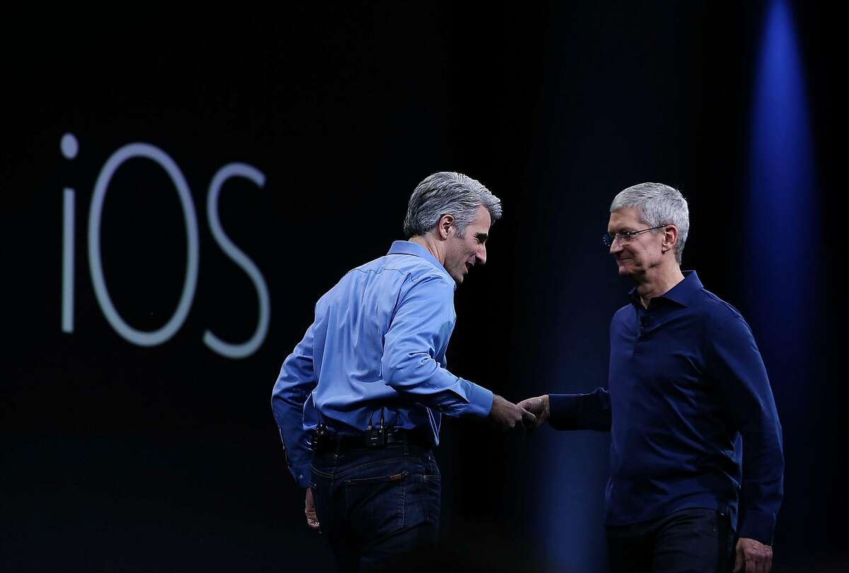 SAN FRANCISCO, CA - JUNE 08: Apple senior vice president of Software Engineering, Craig Federighi (L), shakes hands with Apple CEO Tim Cook during the Apple WWDC on June 8, 2015 in San Francisco, California. 