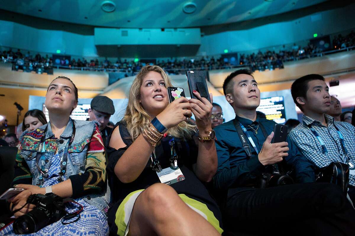 Lenovo insiders Jasmine Fatschild, Lizza Monet Morales, and Jia Liu take photos and video during the announcement of Lenovo's Tango-enabled smartphone at its Tech World conference in San Francisco.