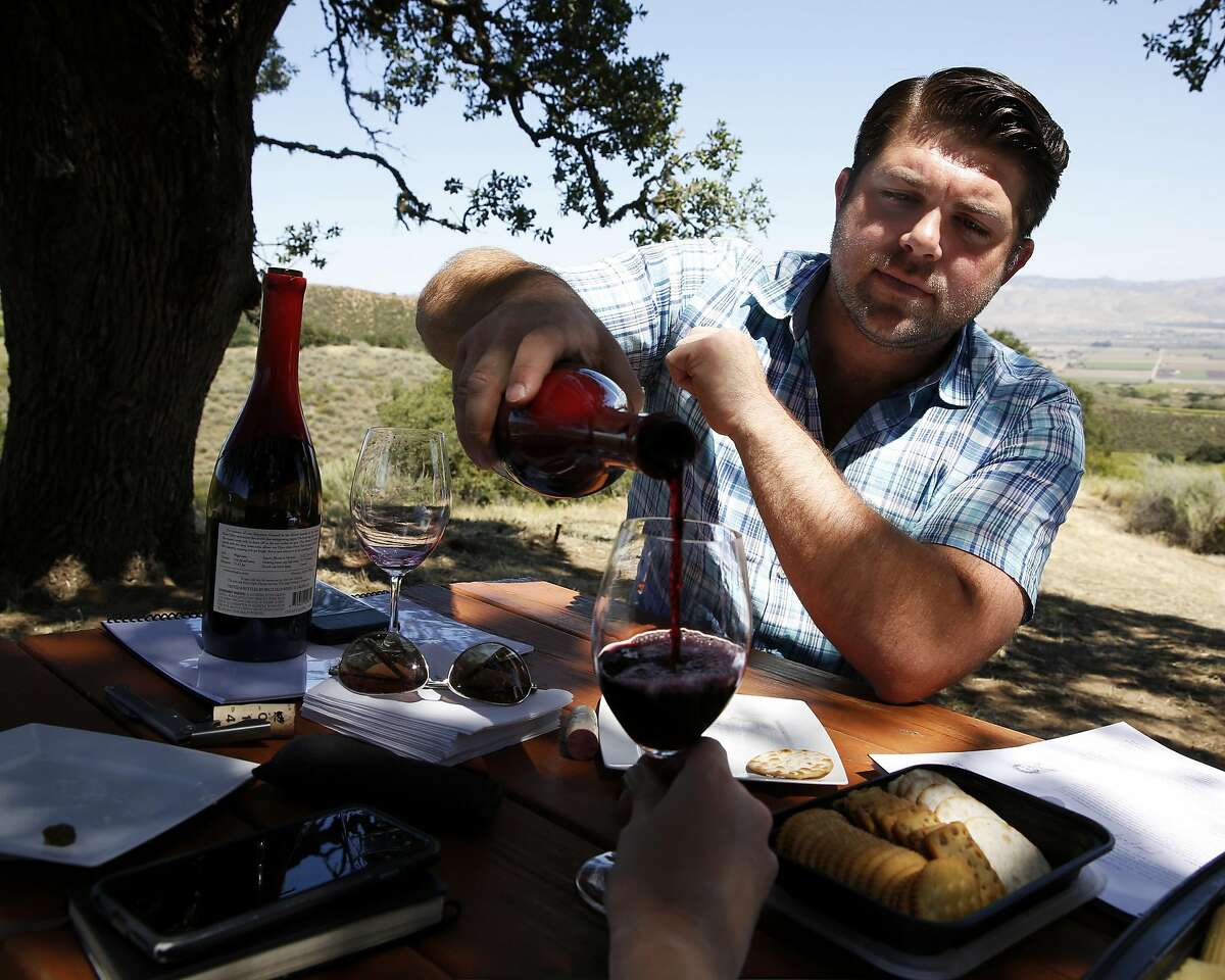 Joe Wagner pours Belle Glos wine during a tasting at a picnic table in the Las Alturas vineyard at the Santa Lucia Highlands in Monterey County, California, on Monday, April 18, 2016.