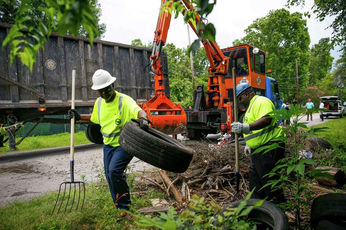 Solid Waste Management employees Dennis Bowen, left, and Avrin Mitchell help remove tires from an illegal dumping site on Wellington Road. City officials, including Mayor Sylvester Turner, held a press conference at the dump site to urge the governor to declare a disaster in order to help the city remove breeding grounds for mosquitos that could carry the zika virus Thursday, June 9, 2016 in Houston.