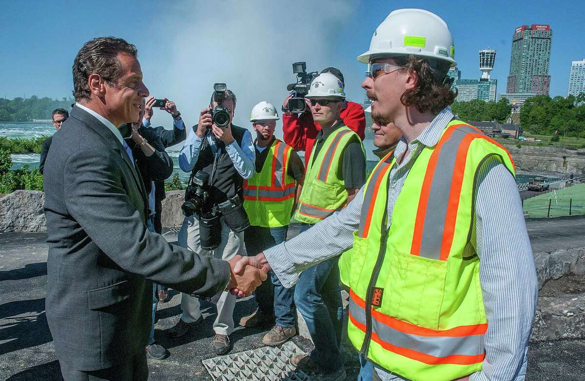 New York Gov. Andrew Cuomo, left, greets construction workers at Terrapin Point while visiting the area to tour construction work at Niagara Falls State Park, Thursday, June 9, 2016, in Niagara Falls, N.Y. The park will get $17 million in state-funded upgrades as part of a broader effort to restore and improve the site. and the state will rename Robert Moses Parkway the Niagara Scenic Parkway. (James Neiss/The Niagara Gazette via AP) BUFFALO NEWS OUT; BATAVIA DAILY NEWS OUT; MANDATORY CREDIT ORG XMIT: NYNIA201